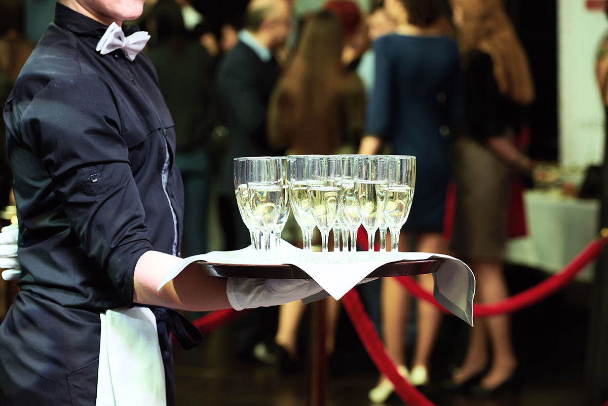 wedding food caterer in black tie attire serving champagne