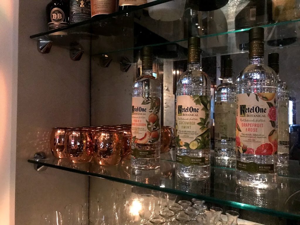 Three bottles of Ketel One vodka on a glass shelf